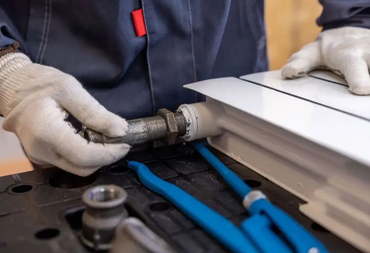 Plumber installing a radiator pipe