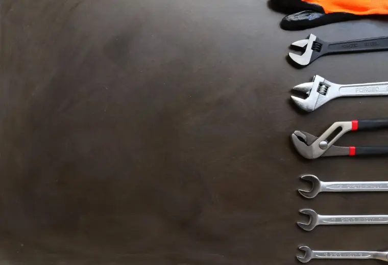 Plumbing wrenches laid out on a work surface
