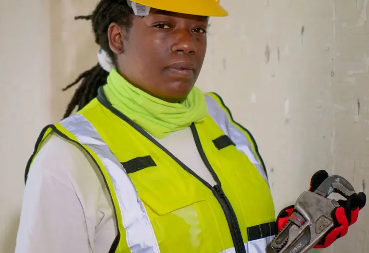Henton technician holding a plumber's wrench on site